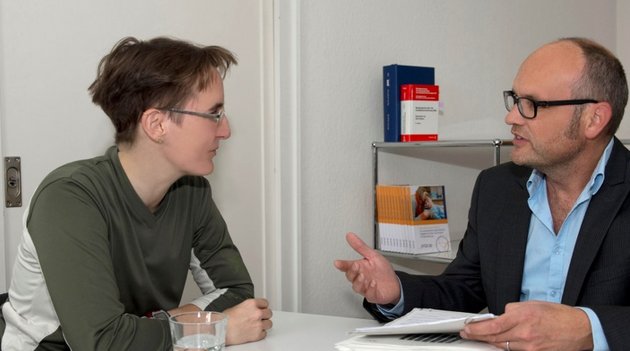 Ein Mann berät eine Frau in Rechtsfragen.